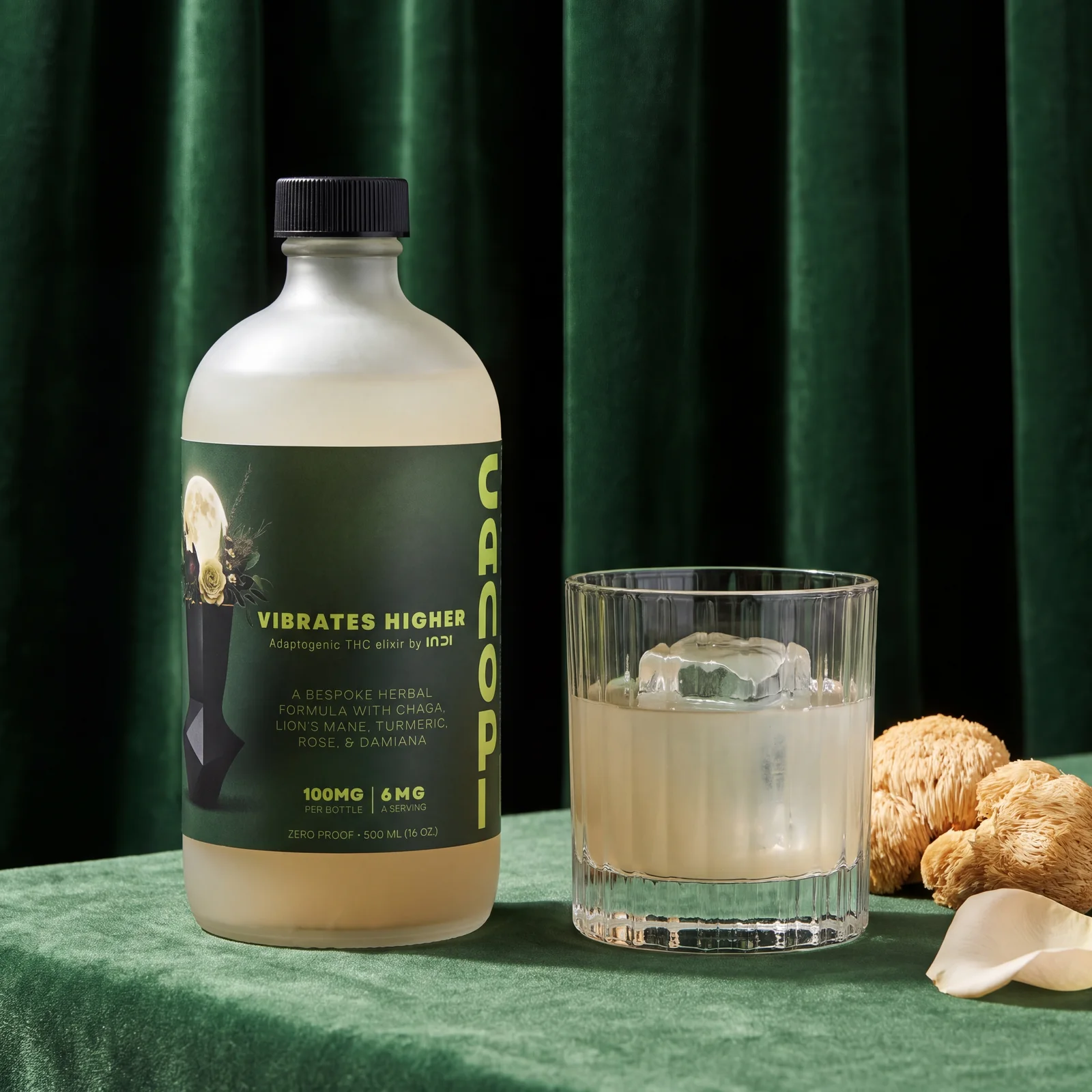 CANOPI bottle beside a rocks glass with a measured pour over ice