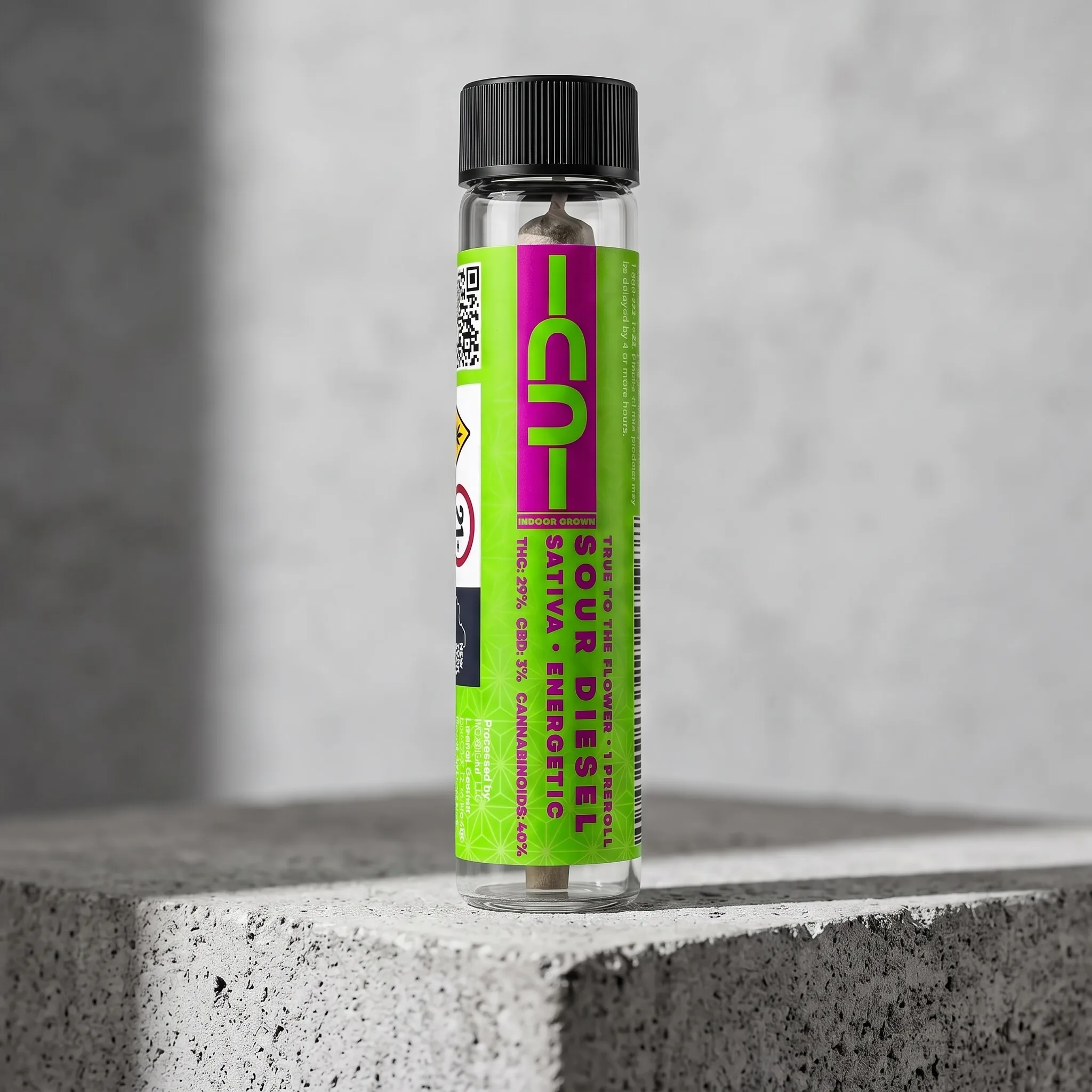 Sour Diesel sativa pre-roll on raw concrete, neon lime and magenta CU label